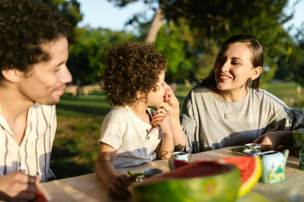 Family enjoying time eating watermelon in their backyard