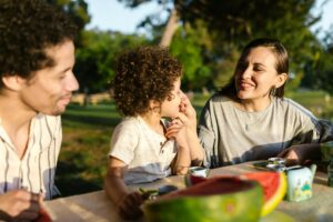 Family enjoying time eating watermelon in their backyard